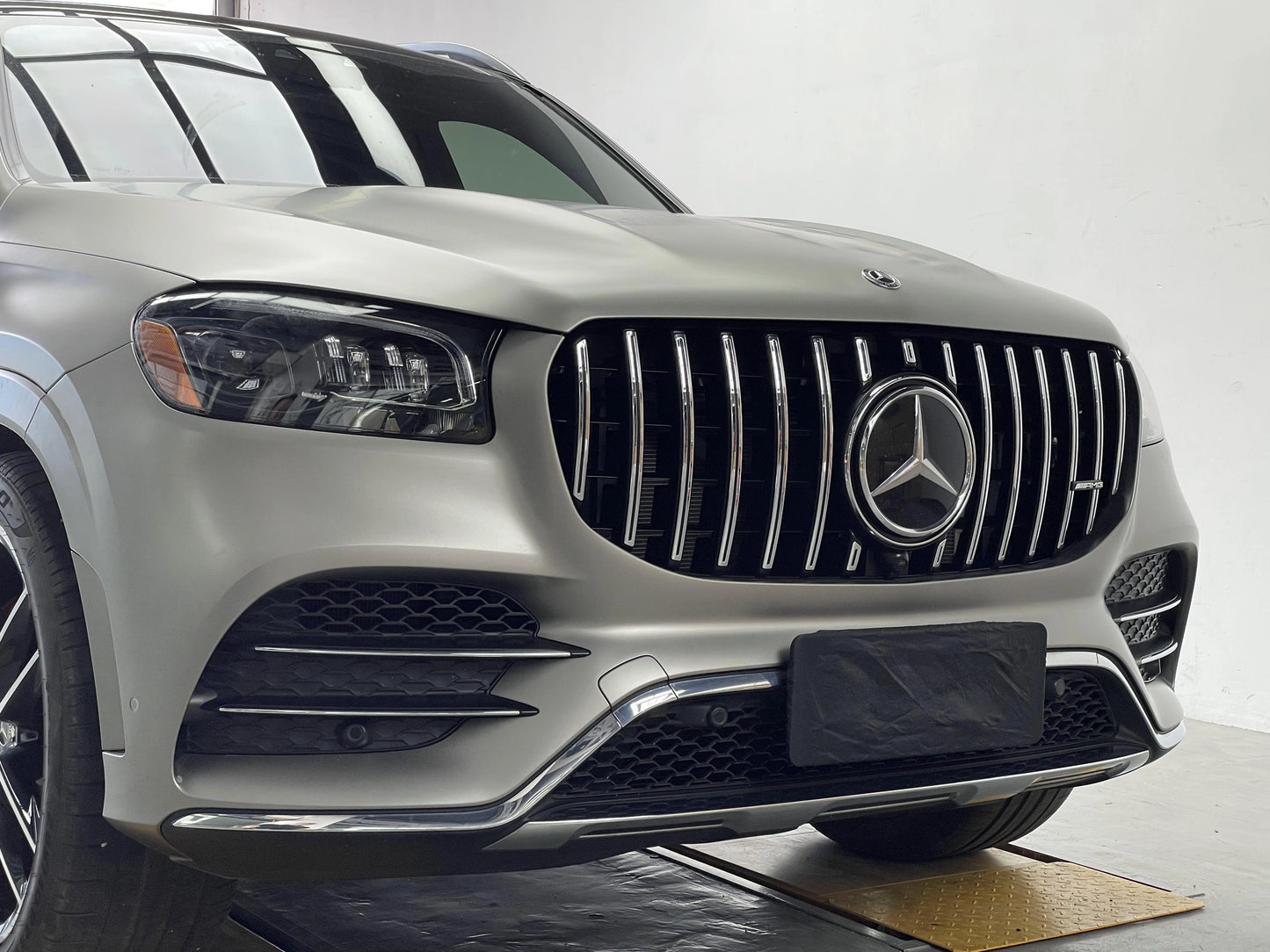 Front bumper view of a Mercedes GLS450 4MATIC X167 highlighting the seamless fitment of the aftermarket AMG style GT grille with chrome accents.